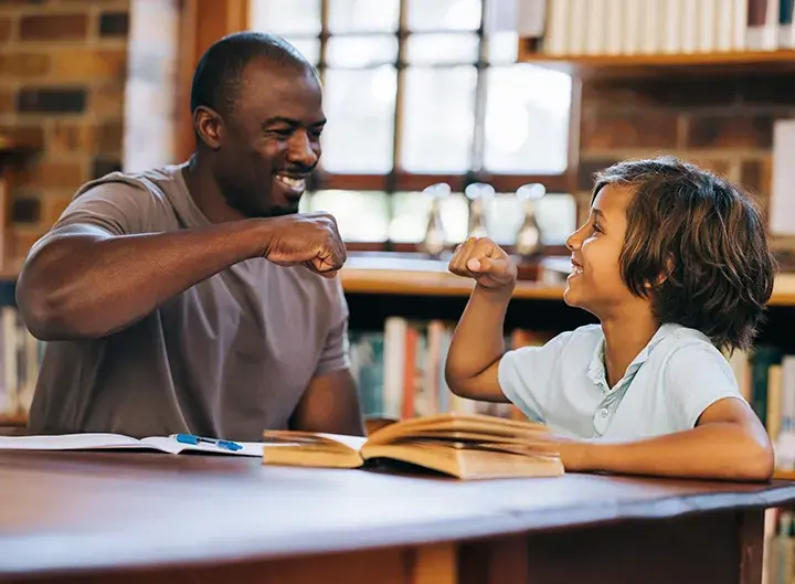 reading tutor fist bumping with kid