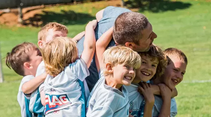 Kids pile on their YMCA coach